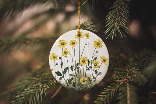a white ornament with yellow flowers hanging from a tree