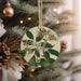 a ceramic ornament hanging from a christmas tree