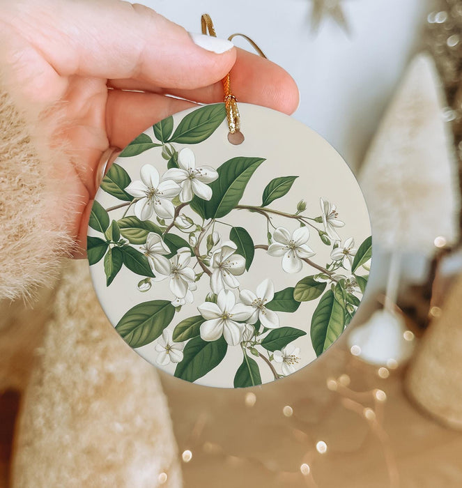 a person holding a white ornament with white flowers on it