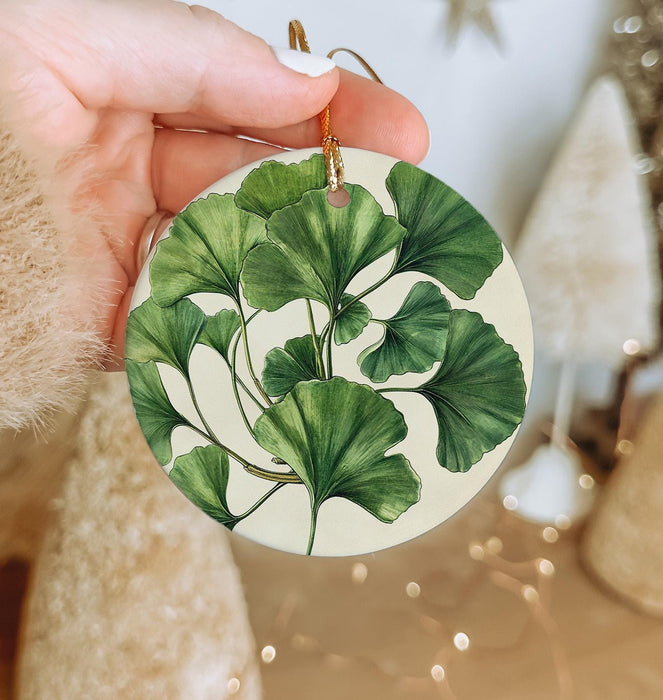 a person holding a green leaf ornament in their hand