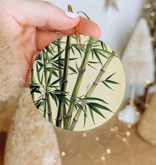 a person holding a round ornament with a bamboo plant on it