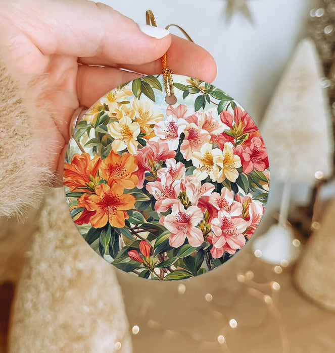 a person holding a christmas ornament with flowers on it