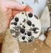 a person holding a round ornament with berries on it