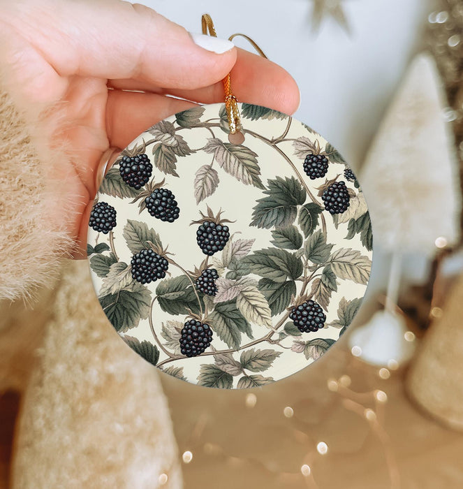 a person holding a christmas ornament with berries on it