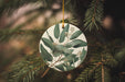 a ceramic ornament hanging from a christmas tree