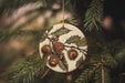 a ceramic ornament hanging from a pine tree
