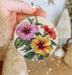 a person holding a flower ornament in their hand