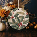 a ceramic ornament decorated with leaves and berries