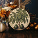 a ceramic ornament with a fruit tree on it