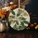 a ceramic ornament with flowers and leaves on a table