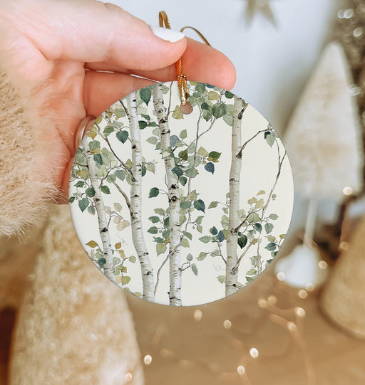 a person holding a paper ornament with a tree on it
