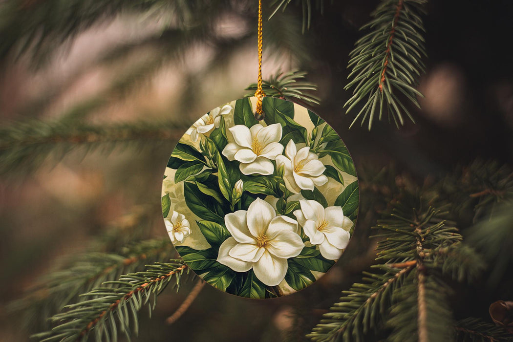 a christmas ornament with white flowers hanging from a tree
