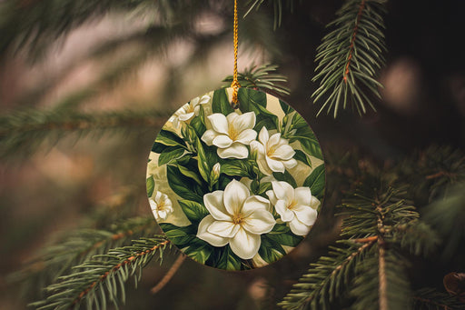 a christmas ornament with white flowers hanging from a tree