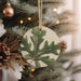 a ceramic ornament hanging from a christmas tree