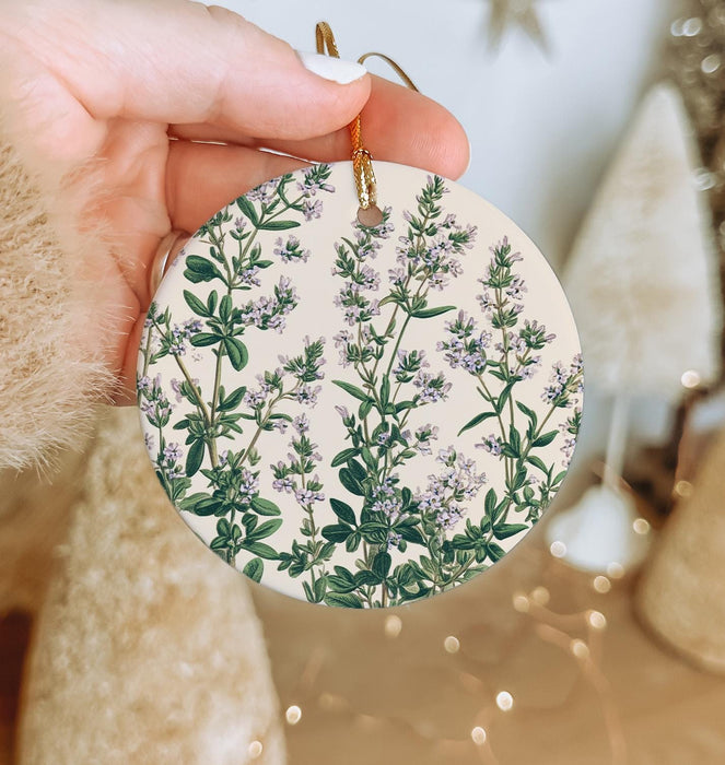 a hand holding a ceramic ornament with a floral design