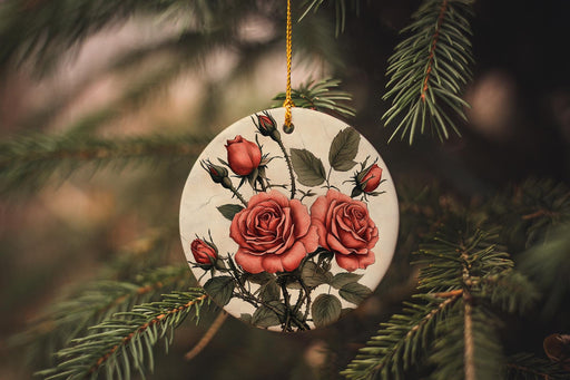a ceramic ornament with red roses hanging from a tree