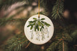a white ornament hanging from a christmas tree