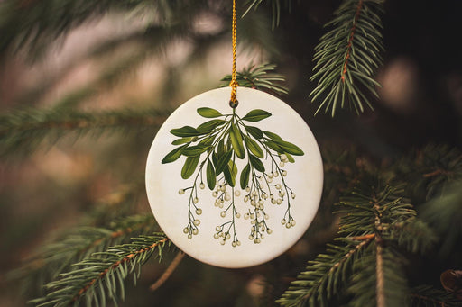 a white ornament hanging from a christmas tree