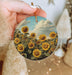 a person holding a sunflower ornament in their hand