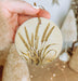 a person holding a round ornament with a plant on it