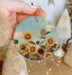 a person holding a sunflower ornament in their hand