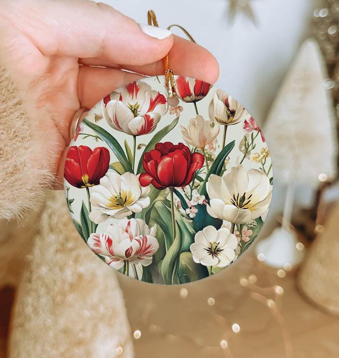 a person holding a christmas ornament with flowers on it