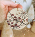 a hand holding a ceramic ornament with berries on it