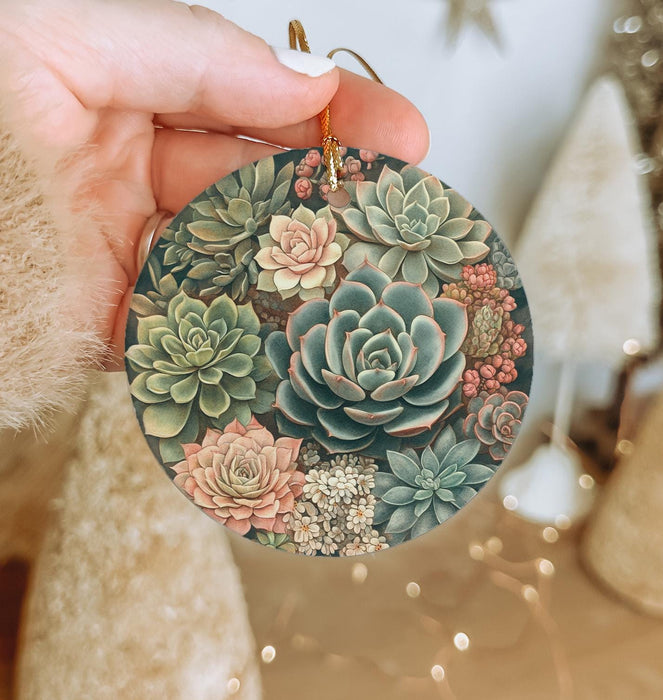a person holding a round ornament with succulents on it