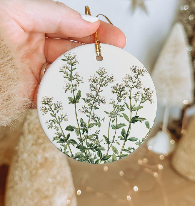 a person holding a round ornament with a plant on it