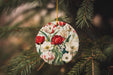 a christmas ornament hanging from a pine tree