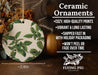 a ceramic ornament with green leaves on it