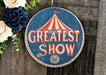 a sign that says greatest show next to flowers