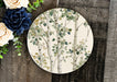 a plate with a tree painted on it next to flowers