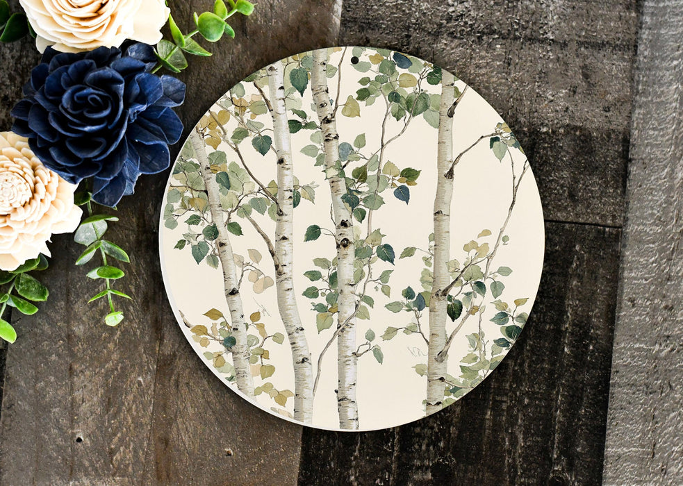 a plate with a tree painted on it next to flowers