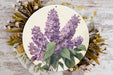 a plate with a painting of purple flowers on it