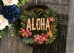 a wooden sign that says aloha surrounded by flowers