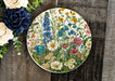 a plate with flowers on it next to a bouquet of flowers