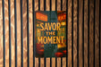 a sign on a wall that says savor the moment