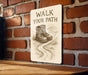 a sign on a brick wall that says walk your path