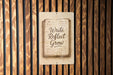 a sign on a wooden wall that says write reflect grow