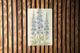 a picture of blue flowers on a wooden wall