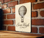 a wooden sign with a hot air balloon on it
