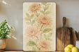 a painting of flowers on a wall next to a cutting board
