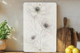 a painting of flowers on a wall next to a cutting board