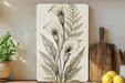 a painting of flowers on a wall next to a cutting board