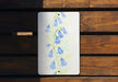 a painting of bluebells on a wooden bench