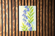 a painting of blue flowers on a wooden wall