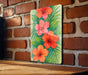 a painting of orange and red flowers on a brick wall