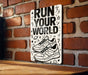 a sign that says run your world on a brick wall