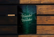 a wooden bench with a sign that says wander in wonder